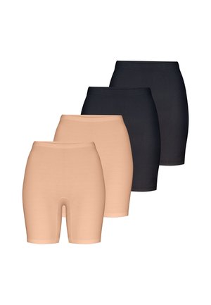 Mujer con pantalones cortos de ciclista ajustados beige y sandalias de tacón alto beige con tiras finas sobre un fondo liso.