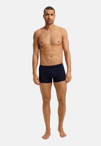 Pánské boxerky tmavě modré barvy z měkké tkaniny, s elastickým pasem a přiléhavým střihem, s hladkým povrchem a minimem švů.