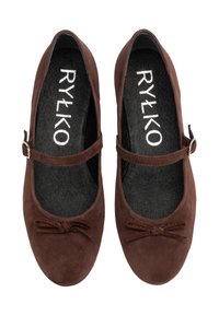 Brown suede Mary Jane flats with a flat sole, rounded toe, bow detail, and adjustable strap featuring a silver-tone buckle.