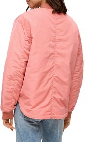 Chaqueta bomber rosa con una textura acolchada, puños acanalados y un dobladillo recto, vista desde la parte posterior. Presenta costuras mínimas y un diseño simple.