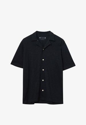 Czarna koszula z krótkim rękawem wykonana z lekkiego materiału. Posiada kołnierz typu camp, zapięcie na guziki z pięcioma białymi guzikami oraz luźny krój.