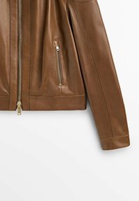 Brun läderjacka med dragkedja fram, dragkedjefickt på sidan och långa ärmar synliga mot vit bakgrund.