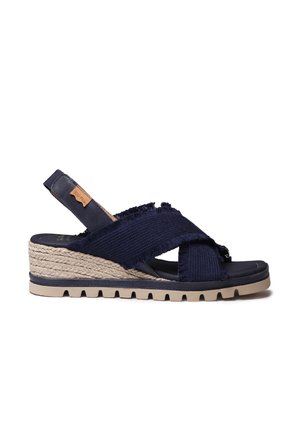 Granatowy sandał na koturnie z frędzlanymi paskami z tkaniny, platformą pokrytą jutą oraz gumową podeszwą z teksturowanym bieżnikiem. Skórzany akcent na pięcie.