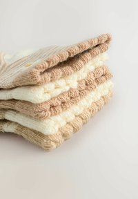 Zestaw dzianych skarpet w naprzemiennych kolorach kremowym i jasnobrązowym. Posiadają ściągacze i teksturowe wzory. Wykonane z miękkiego wełnianego materiału.