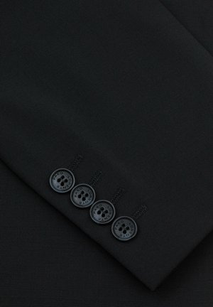 Czarna tkanina o gładkiej fakturze, z obszyciem rękawa i czterema czarnymi guzikami z detalami tekstowymi. Proste przeszycia akcentujące.