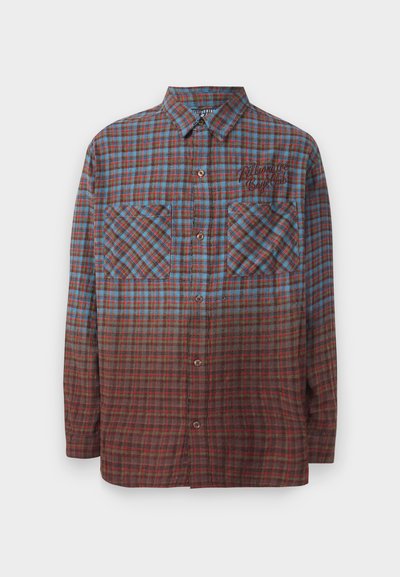 Knoopshirt van plaid in blauw, rood en bruin tinten. Beschikt over twee borstzakken en een geborduurd logo aan de linkerkant. Lange mouwen.