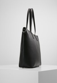 Černá kožená taška přes rameno s elegantním obdélníkovým designem, dvojitými uchy a minimálním prošíváním. Hladký povrch a otevřená horní část.