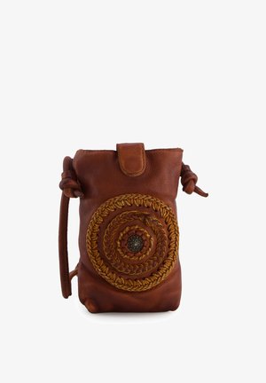 Mała brązowa skórzana saszetka z okrągłym plecionym wzorem na środku i klapką u góry, z węzłowym paskiem po obu stronach.