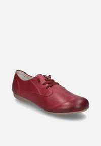 Scarpe di cuoio rosse con lacci, dalla texture liscia, punta arrotondata e suola bassa e flessibile. Tra le caratteristiche ci sono cuciture decorative e occhielli.