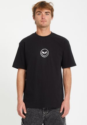 Schwarzes Baumwoll-T-Shirt mit einem runden weißen Logodesign auf der Brust. Kurze Ärmel und klassischer Rundhalsausschnitt.