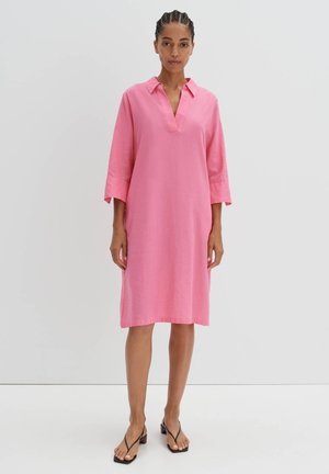 Robe en lin rose avec un col, des manches trois-quarts et une silhouette droite. Elle présente une coupe ample et un design minimaliste.