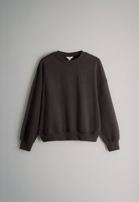 Tumepruun puuvillast dressipluus, millel on ümara kaelusega, pikad varrukad, langevad õlad ning soonikkoes varrukaotsad ja alumine serv. Sile tekstuur.