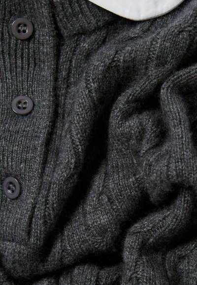Cardigan lavorato a maglia grigio scuro con un motivo testurizzato, cinque bottoni neri sulla parte anteriore e un dettaglio del colletto bianco.