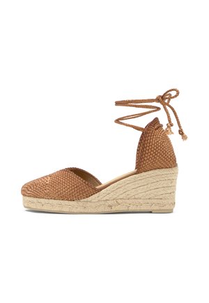 Sandalia espadrille de cuña marrón tejida con lazos alrededor del tobillo y suela plataforma trenzada de yute.