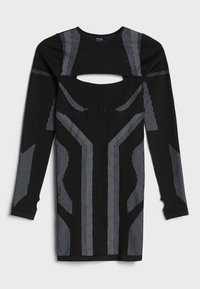 Mustat pitkät hihat mekko, jossa on leikkaus vyötäröllä. Mekossa on pystysuoria valkoisia viivoja ja tekstuurinen kuosi koko kankaan alueella.