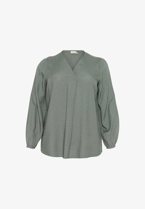 Roheline, pika varrukaga pluus V-kaelusega ja tekstuurse täppmustriga. Omab kokku kogutud varrukaotste ja voolavat siluetti. Kerge kangas.