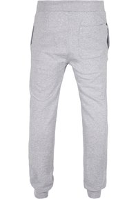 Grå bomullssweatpants med elastisk midja, sidfickor och ribbade muddar. Tyget har en slät struktur.