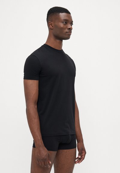 Schwarzes T-Shirt mit kurzen Ärmeln aus glattem Stoff, mit Rundhalsausschnitt und schmaler Passform, getragen mit passenden schwarzen Boxershorts.
