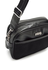 Bolso negro con una parte superior de imitacion de cuero brillante y un fondo de malla texturizada. Presenta un zipper plateado y un logo en la parte frontal. Correa ajustable.