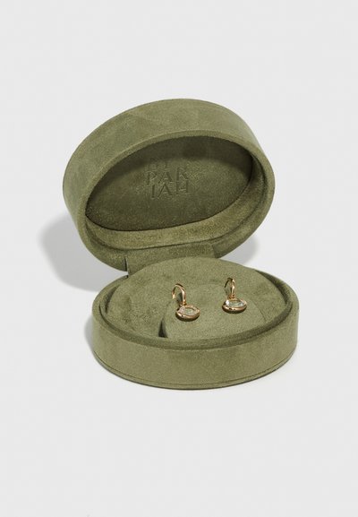 Žalias suede papuošalų dėklas, kuriame yra du auksiniai auskarai su skaidriomis akmenukų detalėmis, ilsisi ant minkšto, atitinkamo vidinio pagrindo.