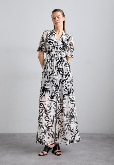 Vestido de manga corta con estampado floral en tejido transparente. Colores blanco y negro, escote en V, cintura ajustada, largo hasta los tobillos con aberturas laterales.