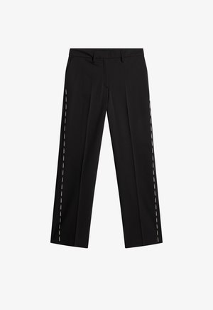 Czarne spodnie o prostym kroju z pętlami na pasek oraz białym, markowym napisem biegnącym pionowo wzdłuż zewnętrznych szwów obu nogawki.