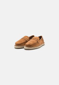 Brown suede slip-on shoes with an espadrille-style jute sole and a stitched accent across the vamp. Smooth texture and rounded shape.