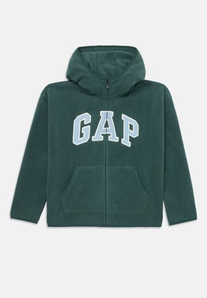 Veste à capuche zippée en polaire vert foncé avec un grand logo "GAP" blanc et bleu clair, deux poches avant et un cordon de serrage.
