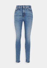 Vaqueros ajustados de denim azul claro con cintura alta, cinco bolsillos y una textura suave. Presenta un ligero desgastado en la parte frontal.