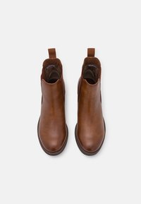 Braune Leder-Stiefeletten mit elastischen Seitenteilen und Zuglaschen. Glatte Textur, abgerundete Spitze und flache Gummisohle.