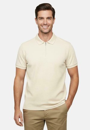 Polo met korte mouwen in lichtbeige met een ritskraag. Gemaakt van gestructureerde stof, met een casual pasvorm en een strakke uitstraling.