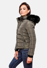 Padded olive green jacket with a detachable black fur hood, featuring zippered pockets and ribbed cuffs, textured horizontal stitching.