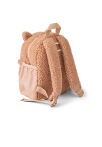 Rucsac mic din pluș în formă de ursuleț, de culoare maro deschis, cu bretele pufoase, mâner superior și buzunar lateral pe fundal alb.