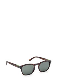 Aurinkoaurinkolasit, joissa on murska-kuvio, harmaat linssit, suorakulmaiset kehykset ja kontrastivihreät yksityiskohdat napeissa. Matta pinta.