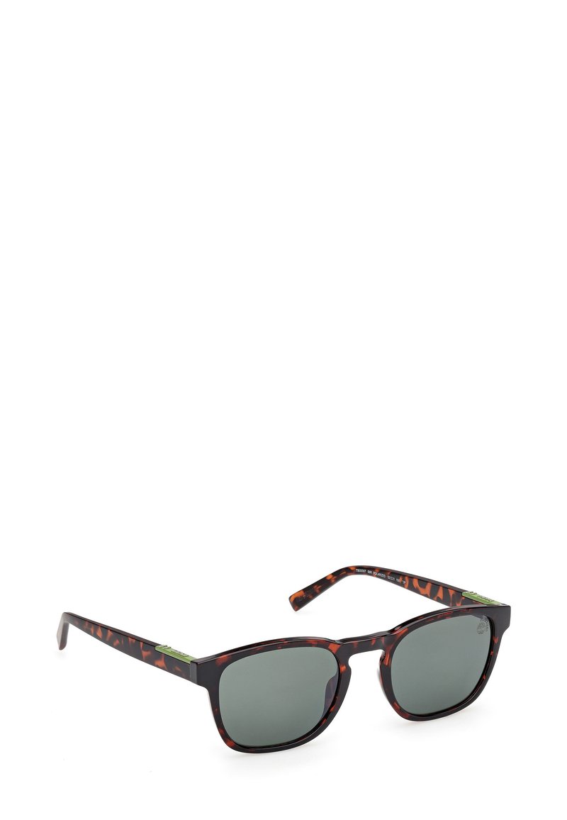 Lunettes de soleil à motif écaille de tortue avec verres gris, monture rectangulaire et accents verts contrastants sur les branches. Fini mat.