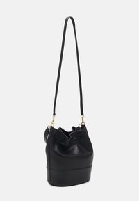 Black leather bucket bag with a drawstring closure, slim shoulder strap, and gold hardware accents. Smooth texture with a structured shape.