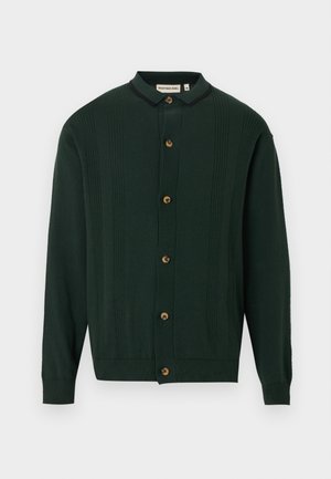 Dark green cardigan with a collar, five wooden buttons, ribbed texture and vertical stripe detailing on the front and sleeves.