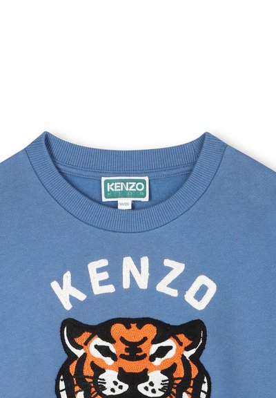 Sweat-shirt bleu avec un col côtelé et un design de tigre brodé. "KENZO" est cousu au-dessus du tigre en blanc. Tissu à texture douce.