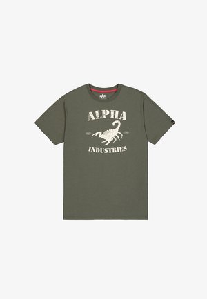 Olívazöld pamut póló fehér skorpió grafikával és vastag betűkkel írt "ALPHA INDUSTRIES" felirattal. Rövid ujjú, kerek nyakú fazon.