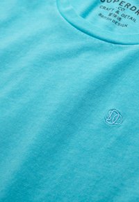 Turquoise korte mouw t-shirt gemaakt van zachte stof, met een ronde hals en een subtiel geborduurd logo rechtsonder.