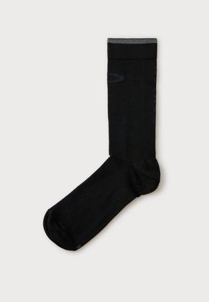 Chaussette noire crew unique avec bord de manchette gris, affichée à plat sur un fond blanc uni.