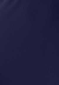 Tmavě modrá látka s hladkou, matnou texturou, na povrchu s jemnými variacemi světla a stínu.