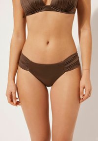 Ensemble bikini marron comprenant un haut triangular et un bas de bikini à taille froncée. Fabriqué en tissu doux et extensible avec un design simple.