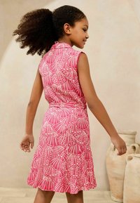 Rotes Kleid mit ärmellosem Design, das über ein Fächer-Muster verfügt. Der Stoff hat eine strukturierte Optik, mit einem ausgestellten Rock und einem Bindegürtel in der Taille.