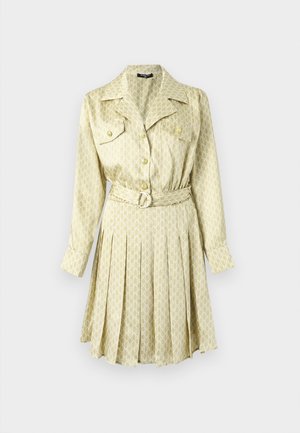 Jasnożółta sukienka z wzorzystej tkaniny, z przodem zapinanym na guziki, kołnierzykiem, długimi rękawami i plisowaną spódnicą; posiada detal w postaci wiązania w talii.