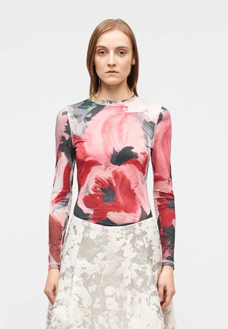 Πολύχρωμο μακρυμάνικο τοπ με λουλουδάτο μοτίβο σε κόκκινους, ροζ και μαύρους τόνους, κατασκευασμένο από απαλό, ελαστικό ύφασμα.