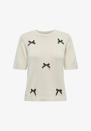 Kreemist lõngast kootud sviiter lühikeste varrukatega, millel on dekoratiivselt paigutatud mustad lipsud esiküljel ja ribakujulised servad kaelas ja varrukatel.