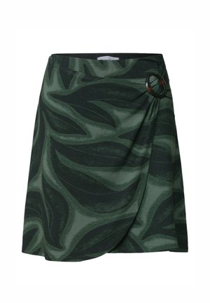 Jupe portefeuille vert foncé avec un grand motif de feuilles et une boucle circulaire noire sur le côté droit à la taille.