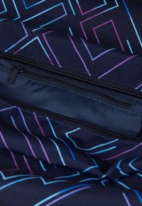 Tessuto blu a fantasia con sottili linee colorate in rosa e blu, con una tasca con zip parzialmente aperta. Superficie texturizzata.
