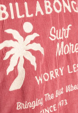 Tissu en velours côtelé rose avec du texte brodé blanc et un motif de palmier. Les phrases clés incluent "Surf More," "Worry Less," avec une surface texturée.
